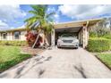Close up of a well maintained home with a covered carport, landscaping, and healthy green lawn at 2104 Hembury Pl # 33, Sun City Center, FL 33573