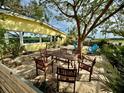 Relaxing backyard patio with wooden table and chairs under a large tree at 304 Patty Dr, Oldsmar, FL 34677