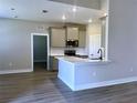 Modern kitchen featuring a breakfast bar, stainless steel appliances, and light gray cabinets at 12152 Snow Bird Ave, Port Charlotte, FL 33981