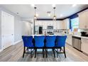 Modern kitchen with white cabinets, stainless steel appliances, and blue accents at 6119 Bradford Woods Dr, Zephyrhills, FL 33542