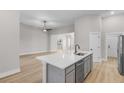 Bright, open-concept kitchen island features stainless steel dishwasher and sink with modern faucet at 5479 Brussels Ter, Port Charlotte, FL 33981