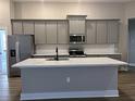 Kitchen island with white quartz countertop and gray cabinets at 5479 Brussels Ter, Port Charlotte, FL 33981