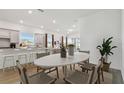 Bright dining room with a large white table and views of the open-concept kitchen and living spaces at 9457 Barnacle Ln, Parrish, FL 34219