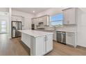 Modern kitchen with an island, stainless steel appliances, and light gray cabinets at 9457 Barnacle Ln, Parrish, FL 34219