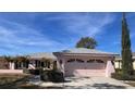 Front view of a pink house with a two-car garage and lush landscaping at 2833 Windridge Dr, Holiday, FL 34691