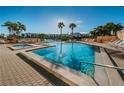 Community pool with hot tub, surrounded by palm trees and lounge chairs at 7625 Sun Island S Dr # 101, South Pasadena, FL 33707