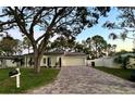 Newly renovated home with a large, paved driveway and mature trees at 2353 Kilgore Dr, Largo, FL 33770