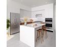 Modern kitchen featuring a marble island, stainless steel appliances, and sleek white cabinets at 400 Central Ave # 3909, St Petersburg, FL 33701