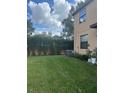 Small grassy backyard with a privacy fence and AC unit at 10235 Villa Palazzo Ct, Tampa, FL 33615