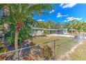 Ranch style home with chain link fence and tropical landscaping at 8012 N Lynn Ave, Tampa, FL 33604