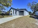 Newly built craftsman style home with gray siding, covered porch, and two-car garage at 8113 N Edison Ave, Tampa, FL 33604