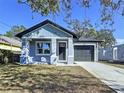 Newly built craftsman style home with gray siding, covered porch, and two-car garage at 8113 N Edison Ave, Tampa, FL 33604