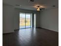 Open-concept living room with hardwood floors and a sliding glass door that leads to a backyard at 31684 Griffin Sands Ln, San Antonio, FL 33576