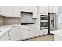 White kitchen with stainless steel appliances and hexagon tile backsplash at 9430 Shorebird Ct, Parrish, FL 34219