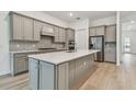 Modern kitchen with gray cabinets, quartz countertops and island at 9433 Barnacle Ln, Parrish, FL 34219