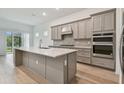 Modern kitchen featuring gray cabinets, quartz countertops, and island at 9433 Barnacle Ln, Parrish, FL 34219