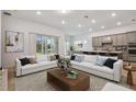 Open-concept living room with modern kitchen, light hardwood floors, and sliding glass doors to the outdoor space at 9433 Barnacle Ln, Parrish, FL 34219