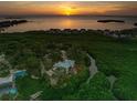 Aerial view of waterfront home with sunset, showcasing its location and private dock at 1580 Mac Chesney Dr, Tarpon Springs, FL 34689