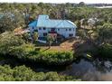 Aerial view showcasing home's rear, pool, and canal-side location at 1580 Mac Chesney Dr, Tarpon Springs, FL 34689