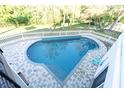 Inviting kidney-shaped pool with brick patio and fenced backyard at 1580 Mac Chesney Dr, Tarpon Springs, FL 34689