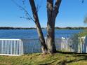 Scenic lake view from backyard, featuring a white vinyl fence and lush green grass at 7123 Colonial Lake Dr, Riverview, FL 33578