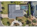 Aerial view of a home showcasing its roof, screened pool, landscaping, and circular driveway at 910 Oakwood Dr, Largo, FL 33770