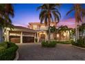 Grand waterfront home with palm trees and brick driveway at 101 12Th E St, Tierra Verde, FL 33715