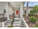 Inviting front entrance with red door, stairs, and seating area at 815 3Rd S Ave, Tierra Verde, FL 33715