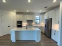 Modern kitchen with island, stainless steel appliances, and white cabinetry at 5732 Silverside Pine Ct, Lakewood Ranch, FL 34211