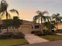 Well-maintained house with a driveway and palm trees at 2226 Sifield Greens Way # 26, Sun City Center, FL 33573