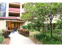 Inviting condo building entrance with landscaped walkway at 3076 Eastland Blvd # 106, Clearwater, FL 33761