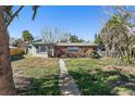 Ranch style home with light green exterior and palm trees at 7060 Boca Ciega Dr, St Pete Beach, FL 33706