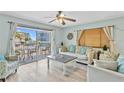 Living room with light walls, wood-look floors, and access to balcony at 19807 Gulf Blvd # 128, Indian Shores, FL 33785