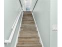 Interior photo of staircase with wood-look tile and white railing at 19807 Gulf Blvd # 128, Indian Shores, FL 33785