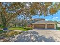 Two-story house with a three-car garage, mature trees, and a large front yard at 5315 Cedarshake Ln, Valrico, FL 33596