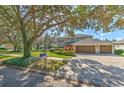 Two-story house with a three-car garage, mature trees, and a large front yard at 5315 Cedarshake Ln, Valrico, FL 33596