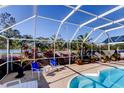 Relaxing pool area with screened enclosure, comfortable seating, and lush landscaping at 8622 Thimbleberry Ln, Tampa, FL 33635