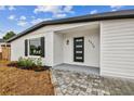 Updated home exterior featuring a modern front door and walkway, and nicely manicured landscaping at 5908 S Manhattan Ave, Tampa, FL 33616