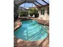 Inviting kidney-shaped pool with a spa and screened enclosure at 297 Martellago Dr, North Venice, FL 34275