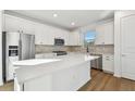 Modern kitchen with white cabinets, stainless steel appliances, and an island at 9442 Shorebird Ct, Parrish, FL 34219