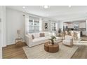 Bright living room with a white sofa, wood floors, large windows, and an open floor plan at 9442 Shorebird Ct, Parrish, FL 34219