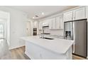 Modern kitchen with white cabinets, stainless steel appliances, and a large island at 9458 Shorebird Ct, Parrish, FL 34219