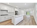 Open concept kitchen with white cabinets, island, and adjacent living area at 9458 Shorebird Ct, Parrish, FL 34219