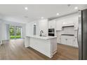 Modern white kitchen with island and stainless steel appliances at 11509 Waterway Dr, Parrish, FL 34219