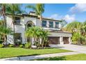 Two-story house with a two-car garage and tropical landscaping at 3405 3405 Loggerhead Way Way, Wesley Chapel, FL 33544