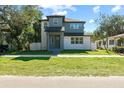 Modern two-story house with gray and white exterior, landscaping, and a paved driveway at 1712 W Arch St, Tampa, FL 33607