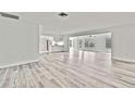 Bright living room with modern flooring and fresh white walls, flowing into the kitchen area at 7231 Big Bend Dr, Spring Hill, FL 34606
