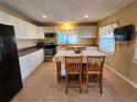 Bright eat-in kitchen with white cabinets, stainless steel appliances, and tiled floor at 10863 112Th Pl, Largo, FL 33778