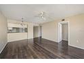 Living area with dark wood floors, ceiling fan, and dining space at 141 Lakeview Way, Oldsmar, FL 34677