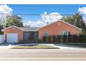 Charming single-story home with a front-facing garage, a landscaped yard, and a classic design under a sunny, blue sky at 463 Park N St, St Petersburg, FL 33710